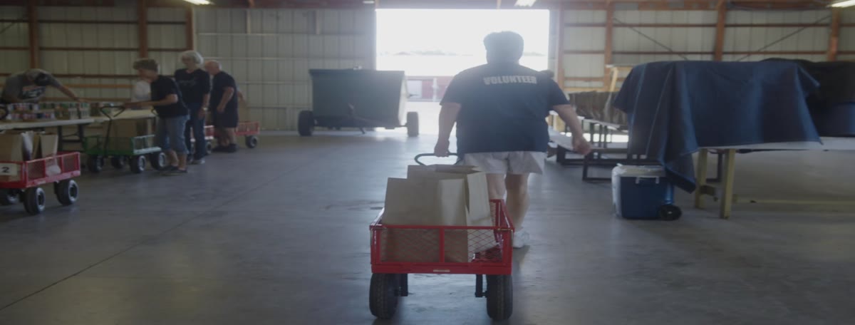 A volunteer pulls a wagon of groceries through the barn