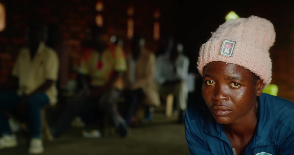 A woman in a knit hat at an evening gathering